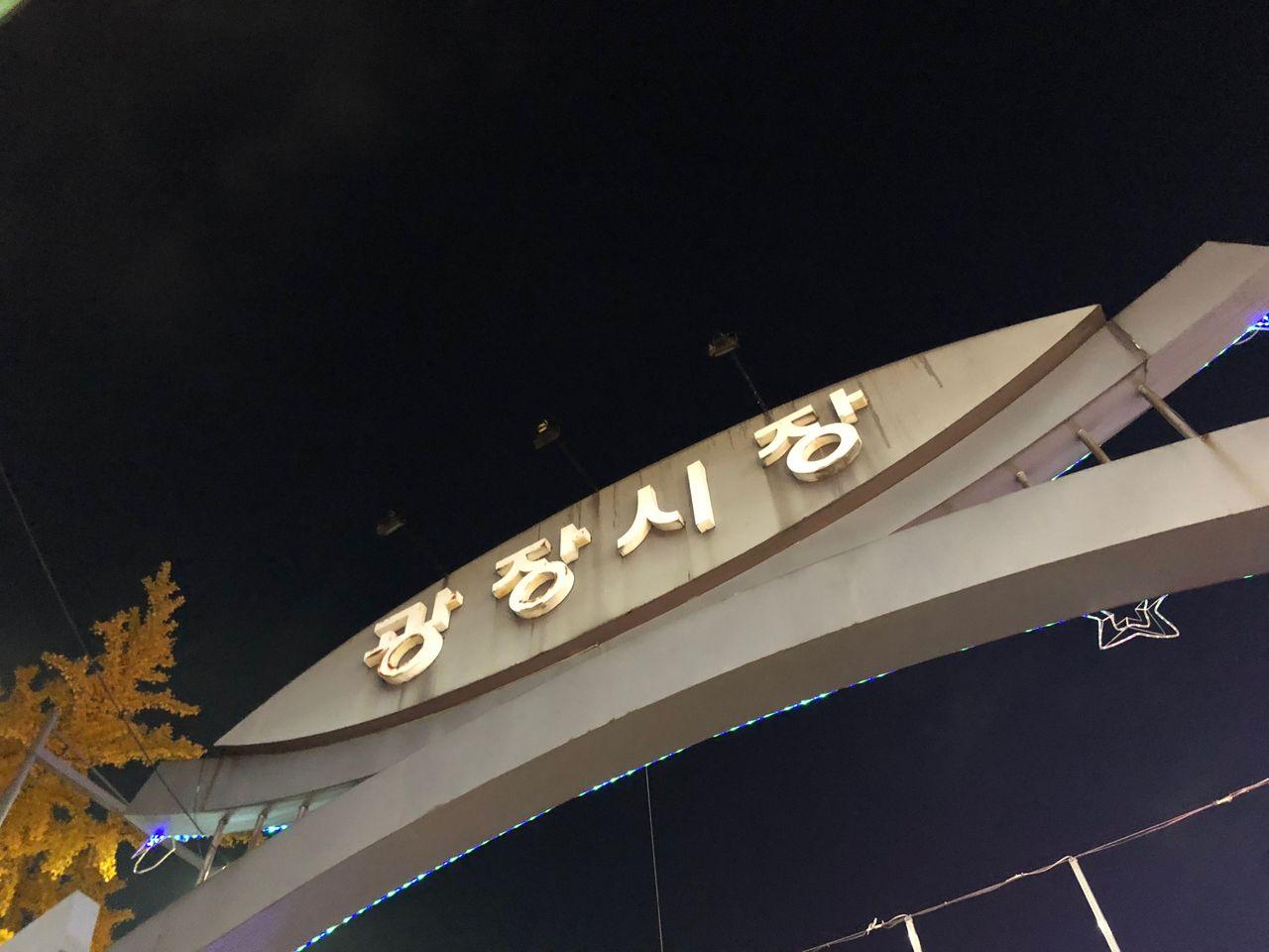 Entrance to Gwangjang Market in Seoul, illuminated at night.